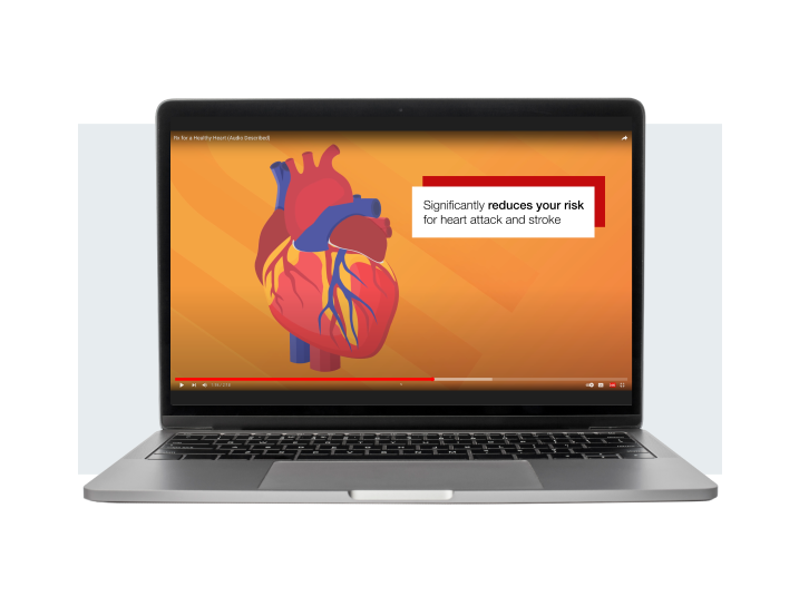 An animated video from the Live to the Beat campaign appears on a laptop screen. The screen shows an illustration of a heart with the caption "significantly reduces your risk for heart attack and stroke." 