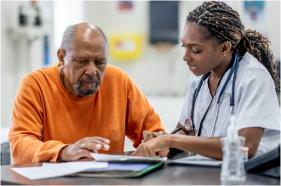 A doctor talks with an older Black patient.