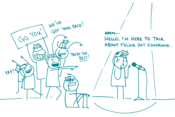 Illustration of a doodle at a microphone, with a cat on their head, saying "Ahem...Hello. I'm here to talk about feline hat syndrome."  as a group of other doodles with cats on their heads cheer, saying "We've got your back!" "You're the best!" and "Yay," with another holding a sign saying "Go you!"